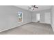 Spacious bedroom with neutral carpet, ceiling fan, and bright window overlooking backyard at 1013 Fieldmere Pl, Wendell, NC 27591