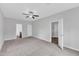 Spacious bedroom with neutral carpet, multiple doorways, and a ceiling fan at 1013 Fieldmere Pl, Wendell, NC 27591