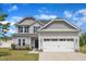 Charming two-story home with a two-car garage, light gray siding, and a well-manicured lawn at 1013 Fieldmere Pl, Wendell, NC 27591
