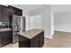Modern kitchen with stainless steel refrigerator, granite countertops, island, and dark cabinets at 1013 Fieldmere Pl, Wendell, NC 27591