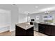 Open kitchen with island, stainless steel appliances, and view into living room and breakfast nook with sliding glass doors at 1013 Fieldmere Pl, Wendell, NC 27591