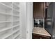 Walk-in pantry with ample white shelving, granite countertops, and dark cabinets at 1013 Fieldmere Pl, Wendell, NC 27591