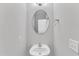 Well-lit powder room featuring a pedestal sink and an oval mirror at 1013 Fieldmere Pl, Wendell, NC 27591
