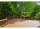 Stained-wood back deck with decorative railing provides a tranquil outdoor space to enjoy a beautiful, wooded setting at 103 Tremont Cir, Chapel Hill, NC 27516