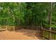 Large stained-wood deck with decorative railing overlooks a lush, green, wooded backyard at 103 Tremont Cir, Chapel Hill, NC 27516