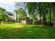 Spacious backyard with manicured lawn, mature trees, and deck, providing privacy and room for outdoor activities at 103 Tremont Cir, Chapel Hill, NC 27516
