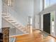 Bright foyer with high ceilings, wood floors, staircase, and a dark front door at 103 Tremont Cir, Chapel Hill, NC 27516