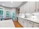 Modern kitchen with white cabinets, tile backsplash, and a view to a window-filled breakfast nook at 103 Tremont Cir, Chapel Hill, NC 27516
