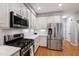 Modern kitchen with stainless steel appliances, white cabinets, and a sleek gas range at 103 Tremont Cir, Chapel Hill, NC 27516