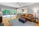 Bright living room with hardwood floors, a leather couch, and sliding doors leading to a backyard deck at 103 Tremont Cir, Chapel Hill, NC 27516