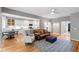 Open-concept living room with hardwood floors, a leather sofa, and a view of the modern white kitchen at 103 Tremont Cir, Chapel Hill, NC 27516
