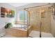 Bathroom area showcasing a tiled soaking tub and a glass-enclosed shower with updated fixtures at 106 Mesquite Dr, Durham, NC 27703