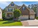 Charming two-story home with a stone and brick facade, a well-manicured lawn, and a two car garage at 106 Mesquite Dr, Durham, NC 27703