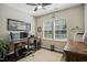 Comfortable home office featuring a wooden desk, dual monitors, and natural light from large windows at 106 Mesquite Dr, Durham, NC 27703