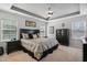 Spacious main bedroom with a dark wood bed frame, neutral carpet, tray ceiling, and bright windows at 106 Mesquite Dr, Durham, NC 27703