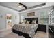 Large main bedroom featuring a dark wood bed frame, tray ceiling, carpet flooring, and natural light at 106 Mesquite Dr, Durham, NC 27703