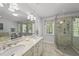 Bathroom with a double vanity, large mirror, and glass-enclosed shower with tile surround at 108 Westport Dr, Cary, NC 27511
