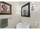 Charming half bathroom with pedestal sink, decorative mirror, sconces, and floral artwork at 108 Westport Dr, Cary, NC 27511