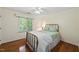 Bedroom with hardwood floors, a ceiling fan, and large window with blinds at 108 Westport Dr, Cary, NC 27511