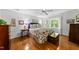 Bright bedroom featuring hardwood floors, neutral walls, ceiling fan, and colorful bedding at 108 Westport Dr, Cary, NC 27511