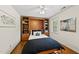 Bedroom featuring a Murphy bed with shelving, a ceiling fan, and hardwood flooring at 108 Westport Dr, Cary, NC 27511