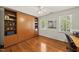 Bedroom with hardwood floors, a Murphy bed with shelving, and two windows with blinds at 108 Westport Dr, Cary, NC 27511