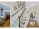 Hallway with carpet stairs, wood railing, and views of other rooms at 108 Westport Dr, Cary, NC 27511