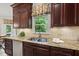 Kitchen sink boasts granite countertops, stainless steel appliances, and dark wood cabinetry at 108 Westport Dr, Cary, NC 27511