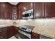 Kitchen features stainless steel oven, microwave, granite countertops, and dark wood cabinetry at 108 Westport Dr, Cary, NC 27511
