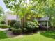 The back exterior of a brick house, showing a screened-in porch and lush landscaping at 110 Blackford Ct, Durham, NC 27712