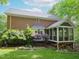 Brick house with screen porch, lush landscaping, and a view of the backyard at 110 Blackford Ct, Durham, NC 27712