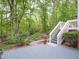 Serene backyard with mature trees, a path, a patio, and stairs leading down to the garden at 110 Blackford Ct, Durham, NC 27712
