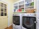 Efficient laundry room with front-loading washer and dryer, storage shelves, and practical layout at 110 Blackford Ct, Durham, NC 27712