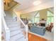 Open living room with staircase, hardwood floors, fireplace, and large windows for natural light at 110 Blackford Ct, Durham, NC 27712