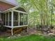 Screened porch with outdoor seating surrounded by landscaping and wooded area at 110 Blackford Ct, Durham, NC 27712