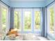 Bright sunroom features walls of windows providing backyard views, natural light and comfortable seating area at 110 Blackford Ct, Durham, NC 27712