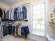 Spacious walk-in closet with built-in shelving, hanging rods, and a window for natural light at 110 Blackford Ct, Durham, NC 27712