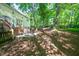 Backyard patio featuring an outdoor seating area with a stone surround and a hammock in the trees at 1166 Nc Highway 87 N, Pittsboro, NC 27312
