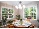 Bright dining room with a round wooden table, overhead lighting, and scenic views from the window at 1166 Nc Highway 87 N, Pittsboro, NC 27312