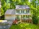 Charming two-story home with a manicured lawn, lush landscaping and a welcoming front porch at 1166 Nc Highway 87 N, Pittsboro, NC 27312