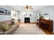 Inviting living room featuring a cozy fireplace, piano, and lots of natural light at 1166 Nc Highway 87 N, Pittsboro, NC 27312