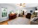 Bright living room featuring hardwood floors, a piano, a ceiling fan and comfortable seating arrangements at 1166 Nc Highway 87 N, Pittsboro, NC 27312