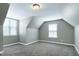 Cozy carpeted room with sloped ceilings and natural light from two bright windows at 120 Shore Pine Dr, Youngsville, NC 27596
