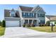 Traditional two-story home with a gray exterior, black shutters, and an attached two-car garage at 120 Shore Pine Dr, Youngsville, NC 27596