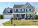 Charming two-story home with a well-manicured lawn, black shutters, and attached two-car garage at 120 Shore Pine Dr, Youngsville, NC 27596