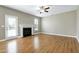 Spacious living room featuring hardwood floors, a cozy fireplace, and a door leading to the backyard at 120 Shore Pine Dr, Youngsville, NC 27596