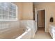 Bathroom featuring a soaking tub, tiled wall and window for natural light at 1208 Copper Creek Dr, Durham, NC 27713