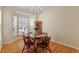 Light-filled dining room with hardwood floors, chandelier, and multiple windows offering natural light at 1208 Copper Creek Dr, Durham, NC 27713