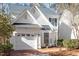 Charming two-story home features a white exterior, attached garage and beautifully landscaped front yard at 1208 Copper Creek Dr, Durham, NC 27713