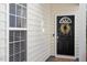 Elegant front door with decorative wreath and welcome mat, complemented by sidelight windows at 1208 Copper Creek Dr, Durham, NC 27713